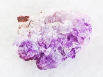 macro shooting of natural mineral rock specimen - Amethyst crystal druse on white marble background from Tersky Coast , Kola Peninsula, Russia