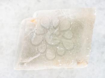 macro shooting of natural mineral rock specimen - rough crystal of Iceland spar gemstone on white marble background from Krutoye, Evenkia in Krasnoyarsk region, Russia