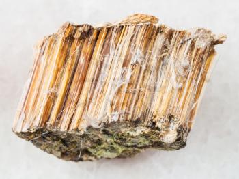 macro shooting of natural mineral rock specimen - raw brown asbestos stone on white marble background from Bazhenovskoye mine in Ural Mountains, Russia