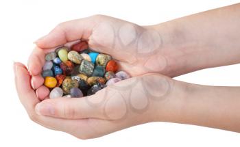 side view of handful with various gemstones isolated on white background