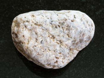 macro shooting of natural mineral rock specimen - white Granite stone on dark granite background