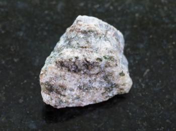 macro shooting of natural mineral rock specimen - raw Apatite ( ore of phosphorus) stone on dark granite background