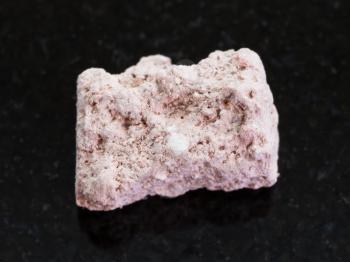 macro shooting of natural mineral rock specimen - rough Kaolinite stone on dark granite background