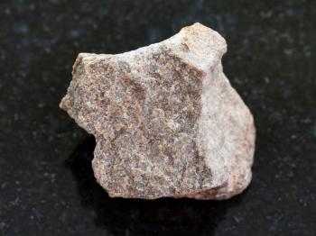 macro shooting of natural mineral rock specimen - rough Quartzite stone on dark granite background