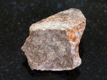 macro shooting of natural mineral rock specimen - raw Quartzite stone on dark granite background