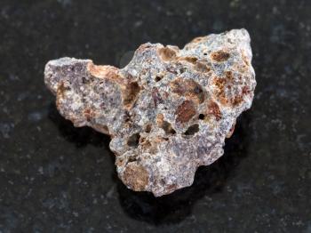 macro shooting of natural mineral rock specimen - Basalt stone on dark granite background