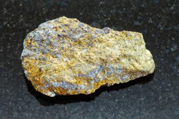 macro shooting of natural mineral rock specimen - rough pyrite ore on dark granite background