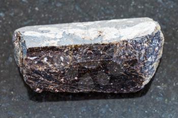 macro shooting of natural mineral rock specimen - crystal of dravite tourmaline gemstone on dark granite background from China