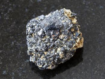 macro shooting of natural mineral rock specimen - rough Perovskite stone on dark granite background