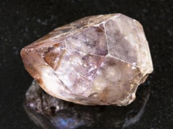 macro shooting of natural mineral rock specimen - amethyst rough crystal on dark granite background from Yakutia, Russia