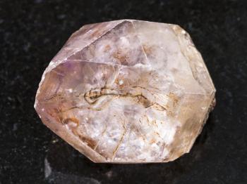 macro shooting of natural mineral rock specimen - rough crystal of amethyst gemstone on dark granite background from Yakutia, Russia
