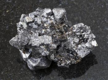 macro shooting of natural mineral rock specimen - rough crystalline Magnetite stone on dark granite background