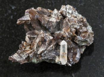 macro shooting of natural mineral rock specimen - raw crystals of axinite stone on dark granite background