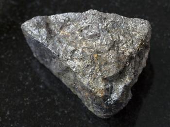 macro shooting of natural mineral rock specimen - raw Arsenopyrite stone on dark granite background from Zabaykalsky Krai, Russia