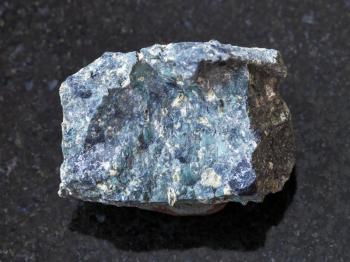 macro shooting of natural mineral rock specimen - rough Kimberlite stone on dark granite background