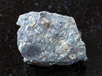 macro shooting of natural mineral rock specimen - raw Kimberlite stone on dark granite background