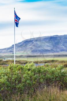travel to Iceland - icelandic flag near Kerid Lake in autumn evening