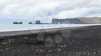 travel to Iceland - Reynisfjara black sand beach and view of Dyrholaey cape in Iceland, near Vik I Myrdal village on Atlantic South Coast in Katla Geopark in september