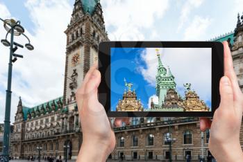 travel concept - tourist photographs Hamburger Rathaus (Town Hall) on Rathausmarkt square in Hamburg city in Germany on tablet
