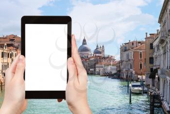 travel concept - tourist photograps Grand Canal and church Santa Maria della Salute in Venice city in Italy in spring on tablet with cut out screen for advertising logo