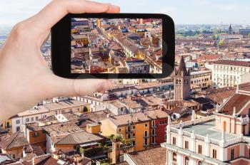 travel concept - tourist photographs Verona cityscape in Italy from tower Torre dei Lamberti in spring on smartphone