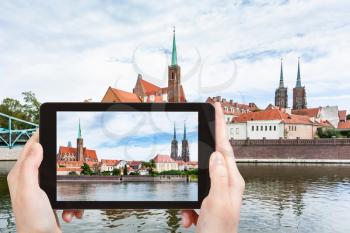 travel concept - tourist photographs Tumski island in Wroclaw city from Oder river on tablet