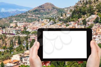 travel concept - tourist photographs Taormina city in Sicily Italy in summer on tablet with cut out screen for advertising logo