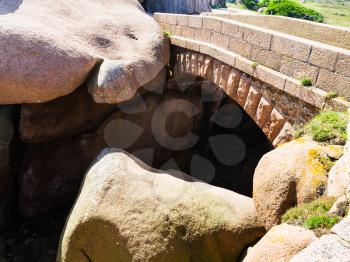 travel to France - stone bridge and bouldes in natural park of Ploumanac'h site of Perros-Guirec commune on Pink Granite Coast of Cotes-d'Armor department of Brittany in sunny summer day