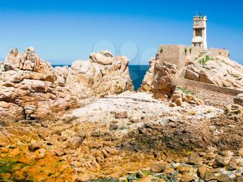 travel to France - Paon Lighthouse (Phare du Paon) on pink granite coast of Ile-de-Brehat island in Cotes-d'Armor department of Brittany in summer sunny day