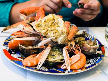 travel to France - visitor eats seafood in local fish restaurant in Treguier town in the Cotes-d'Armor department of Brittany