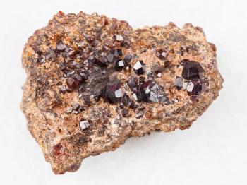 macro shooting of natural mineral rock specimen - Andradite garnet crystals on stone on white marble background from Primorsky Krai, Russia