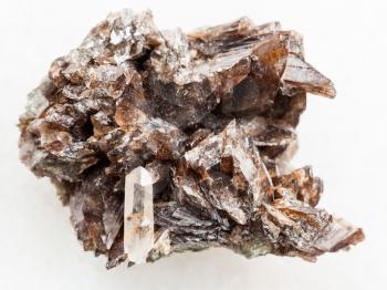 macro shooting of natural mineral rock specimen - crystals of axinite stone on white marble background