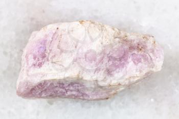 macro shooting of natural mineral rock specimen - raw Ussingite stone on white marble background from Punkaruayv mine, Lovozero Massif, Kola Peninsula, Russia