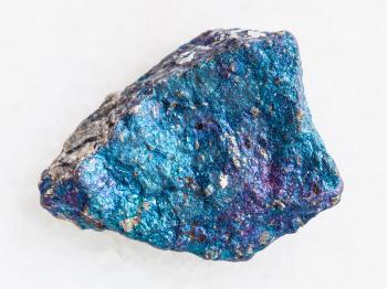 macro shooting of natural mineral rock specimen - raw blue Chalcopyrite stone on white marble background from Mexico