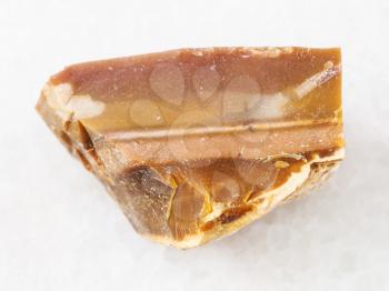 macro shooting of natural mineral rock specimen - brown Flint stone on white marble background