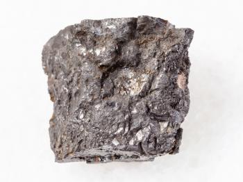 macro shooting of natural mineral rock specimen - rough Bituminous coal stone on white marble background