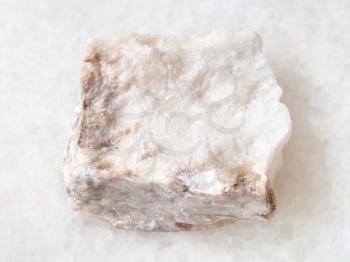 macro shooting of natural mineral rock specimen - rough Anhydrite stone on white marble background