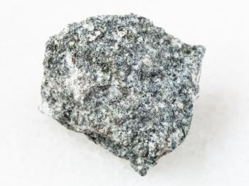 macro shooting of natural mineral rock specimen - rough Diorite stone on white marble background