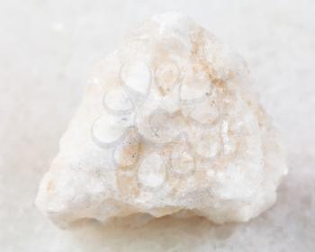 macro shooting of natural mineral rock specimen - rough anhydrite stone on white marble background from Adygea, Russia