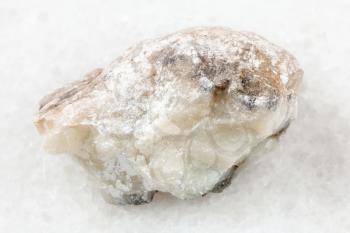 macro shooting of natural mineral rock specimen - raw talc stone on white marble background from Irkutsk region