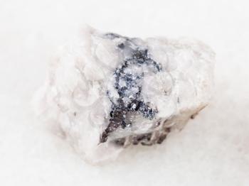 macro shooting of natural mineral rock specimen - rough Wolframite ore on white marble background from North Caucasus
