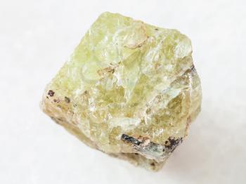 macro shooting of natural mineral rock specimen - raw crystal of Saamite (fluorapatite) gemstone on white marble background from Lovozero Massif, Kola peninsula, Russia