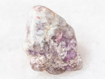 macro shooting of natural mineral rock specimen - Tourmaline crystas in Lepidolite mica in quartz pebble on white marble background from Kalba mine, Kazakhstan