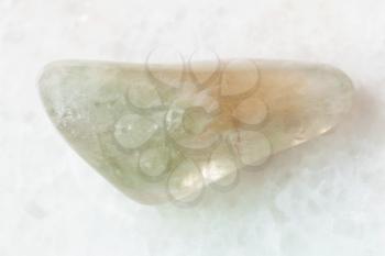 macro shooting of natural mineral rock specimen - polished Prasiolite (green quartz) gemstone on white marble background from Brazil