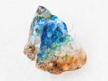 macro shooting of natural mineral rock specimen - tennantite crystal, green Tyrolite and blue Azurite on quartz stone on white marble background from Ural Mountains, Russia