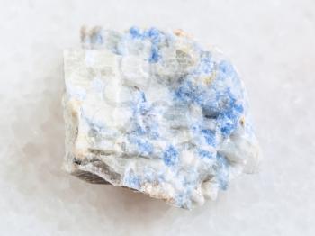 macro shooting of natural mineral rock specimen - vishnevite stone on white marble background from Kurochkin log mine, South Ural, Russia