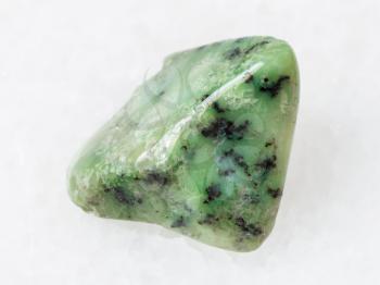 macro shooting of natural mineral rock specimen - green Grossular garnet gemstone on white marble background from South Africa