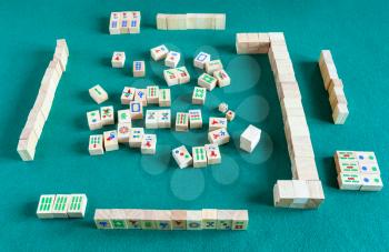 above view of gameboard of mahjong game, tile-based chinese strategy board game on green baize table