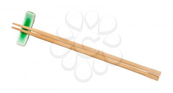 top view of beech wooden chopsticks served on chopstick rest isolated on white background