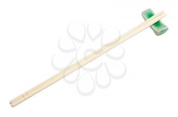 carved disposable wooden chopsticks served on chopstick rest isolated on white background